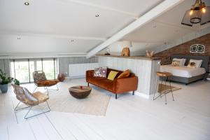 a living room with a bed and a couch at Loft in de Polder in Grootschermer