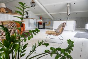 a living room with a couch and a chair at Loft in de Polder in Grootschermer