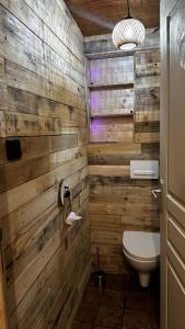 a bathroom with wooden walls and a toilet at l'Orée des Moraines in Monnet-la-Ville +9 photos