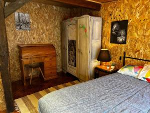 a bedroom with a bed and a dresser and a desk at l'Orée des Moraines in Monnet-la-Ville