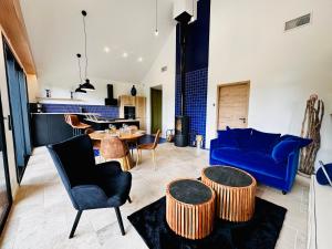a living room with a blue couch and a table at L'Instant Cottage, Chic et Spa près d'Amboise in Saint-Règle