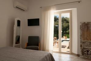 a bedroom with a bed and a sliding glass door at Chrysalis Nature Villa 4 in Kampos Paros