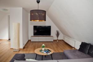 a living room with a couch and a tv at Henning 2 in Kirchdorf