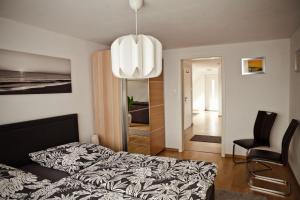 a bedroom with a bed and a chandelier at Henning 2 in Kirchdorf