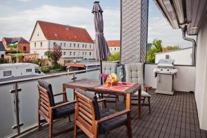 a balcony with a table and chairs and an umbrella at Henning 2 in Kirchdorf