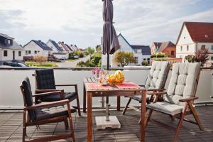 a table and chairs on a balcony with an umbrella at Henning 2 in Kirchdorf