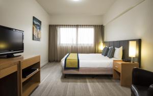 a hotel room with a bed and a flat screen tv at Aligned Corporate Residences Mackay in Mackay