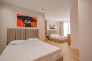 a bedroom with two beds and a painting on the wall at Queen Residence & Hotel in Shëngjin