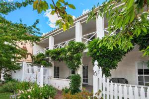 a white house with a white picket fence at Lake Daylesford Apartments 5 in Daylesford