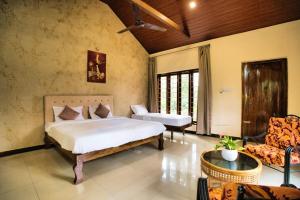 a bedroom with a bed and a couch and a chair at Coffee County in Srimangala
