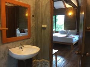 a bathroom with a sink and a bedroom with a bed at Phoxay Ngam Resort in Vang Vieng +162 photos