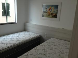 1 dormitorio con 2 camas y una foto en la pared en Atalanta I, en Bombinhas