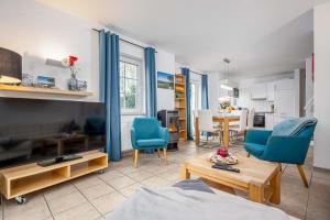 a living room with blue chairs and a table at Seestrasse Haus 15 in Zingst