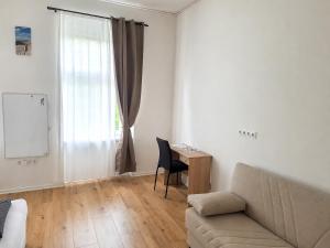 a living room with a couch and a table and a window at BaB Hotels and Apartments Apolo 3 in Chemnitz