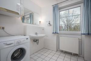 a bathroom with a washing machine and a sink at Seestrasse Haus 15 in Zingst