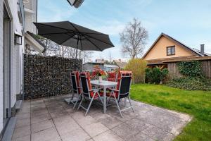 a table and chairs with an umbrella on a patio at Seestrasse Haus 15 in Zingst