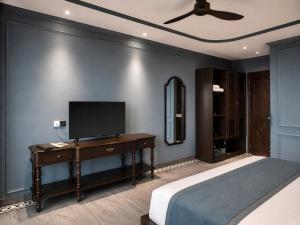 a bedroom with a bed and a television on a desk at Lumina Premium- HT Boutique 2 - Đống Đa in Da Lat