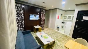 a living room with a blue couch and a table at Al Raiyan Serviced Apartments in Taif