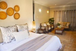 a bedroom with a bed and a living room at Ponciana Superior Guesthouse in Hartbeespoort +45 photos