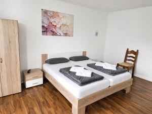 a bedroom with a bed and a wooden chair at BaB Hotels and Apartments Apolo 3 in Chemnitz