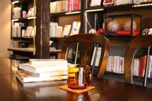 a table with books and a glass of whiskey and books at HARUYA Umekoji in Kyoto