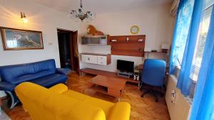 a living room with a yellow couch and a table at Apartments Žgogo in Trogir
