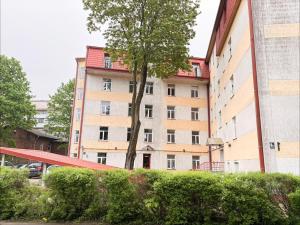 a tall building with a tree in front of it at Nice&cozy flat No7 in Riga