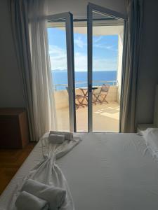 a bedroom with a bed with a view of the ocean at Hotel Lusini in Vlorë +24 photos