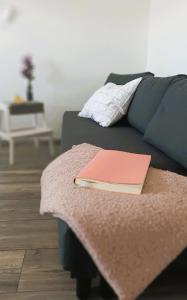 a book sitting on top of a couch with a blanket at apartma Vila TARA in Prebold