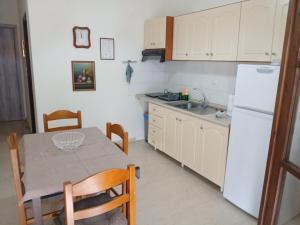 a kitchen with a table and a white refrigerator at Giotis apartments in Leptokarya