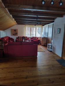 a living room with red couches and a kitchen at SunKiss in Melnragė