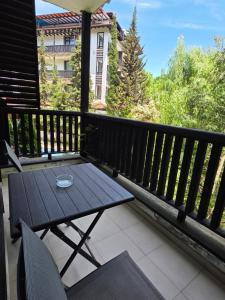 a wooden table and chairs on a balcony at Green apartments in Primorsko +47 photos