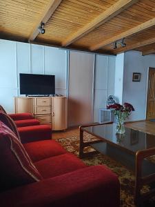 a living room with red chairs and a table and a television at SunKiss in Melnragė