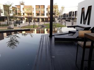 a building with a reflection of a tree in the water at New Loft Modern Home in Hang Dong