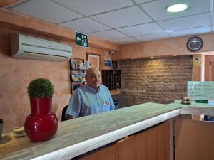 a man standing behind a counter in a room at Pension Segura in Murcia