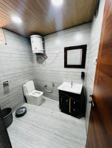 a bathroom with a toilet and a sink at Countryside forest village in Udhampur +19 photos