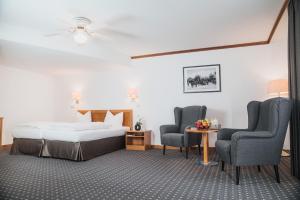 ein Hotelzimmer mit einem Bett und zwei Stühlen in der Unterkunft Hotel Alekto in Freiberg