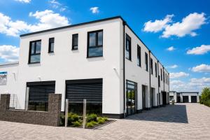 a white building with black windows at StayIN Suites in Griesheim
