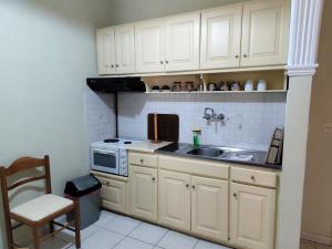 a kitchen with white cabinets and a sink at Maritsas Apartments in Roda +32 photos