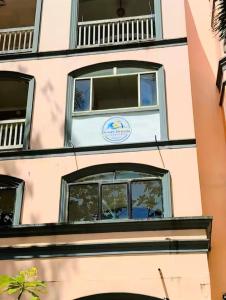 a building with windows and a sign on it at Ocean Breeze Carita in Carita +1 photo