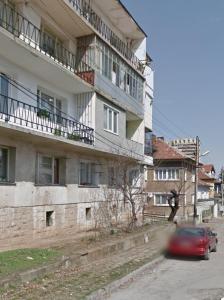 a red car is driving past a building at Апартамент "Smiley Place" in Vratsa