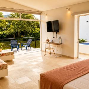 a bedroom with a bed and a television and a patio at La Masia Hotel Boutique in Anapoima