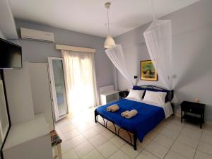 a bedroom with a blue bed with two towels on it at Maritsas Apartments in Roda