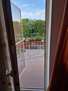 an open door with a view of a balcony with flowers at Apartament Maia in Turda