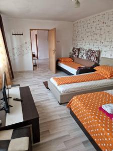 a room with two beds and a table and a desk at Apartament Maia in Turda +5 photos