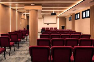 a lecture room with red chairs and a screen at Twin Burj Hotel in Nouakchott