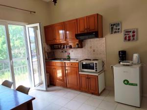a kitchen with wooden cabinets and a white refrigerator at Maritsas Apartments in Roda