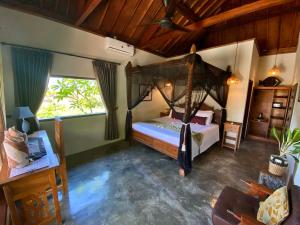 a bedroom with a canopy bed in a room at Ombak Resort at Ekas , a luxury surf and kite destination, Close to Inside Ekas beach in Ekas