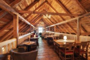 a restaurant with tables and chairs in a wooden ceiling at Kråen Gard in Larsnes +59 photos
