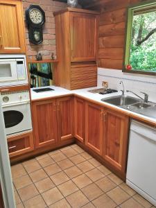 cocina con armarios de madera, fregadero y reloj en Hilltop, en Stirling